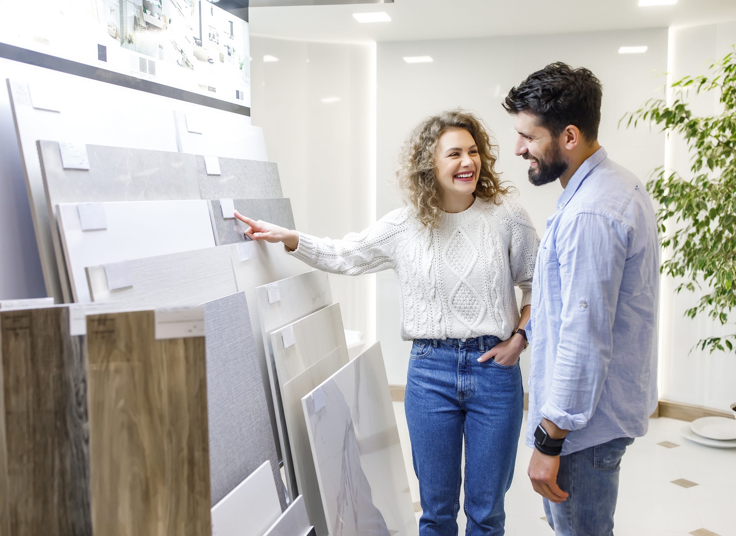 Successful  caucasian couple choosing ceramic tiles for their new house repairment in the building shop